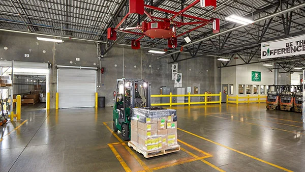 ODFL forklift moving a wrapped pallet in a service center with automated scanning equipment.